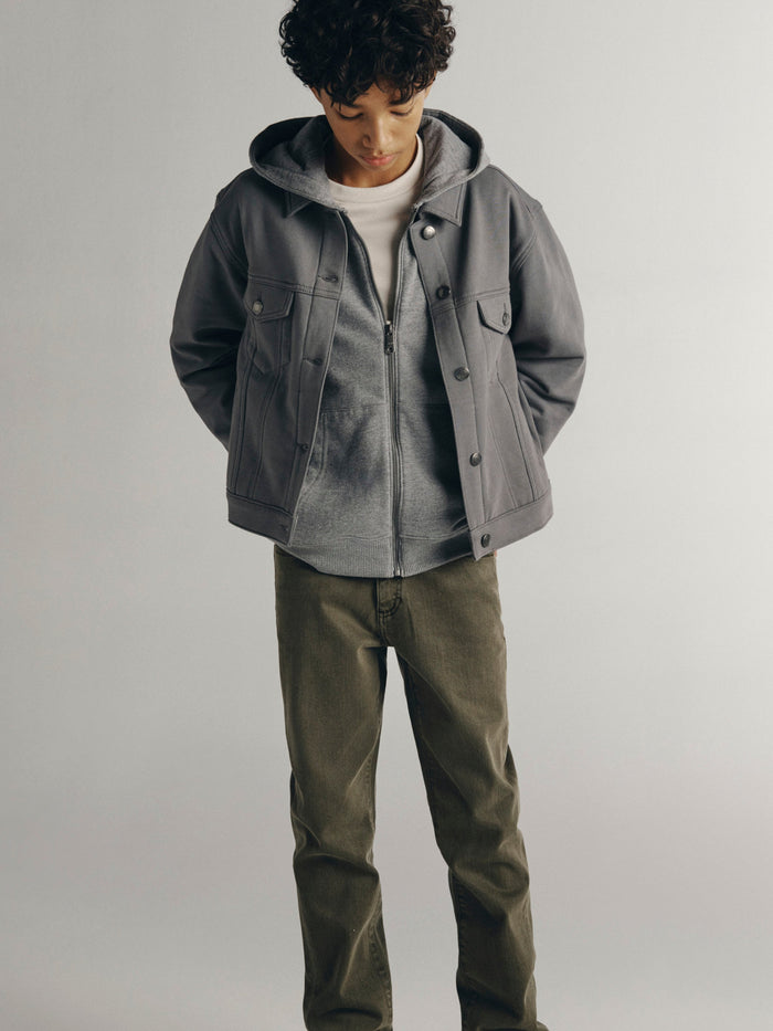 DL1961 boys' Brady Slim jeans in olive 'Outpost' with a gray hooded trucker jacket, cropped front view.