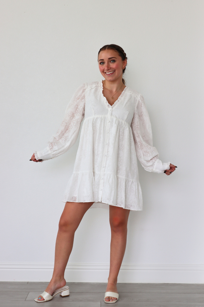 girl wearing white long sleeve floral dress