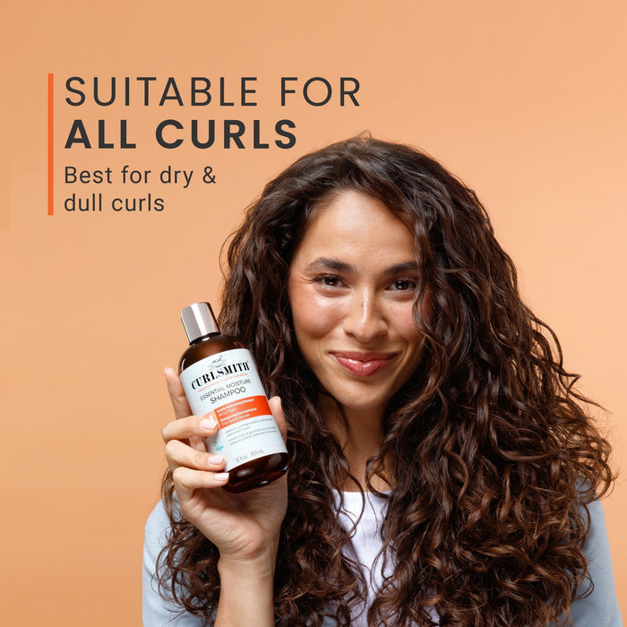 Woman holding a bottle of hair care product with text about suitability for all curls on an orange background