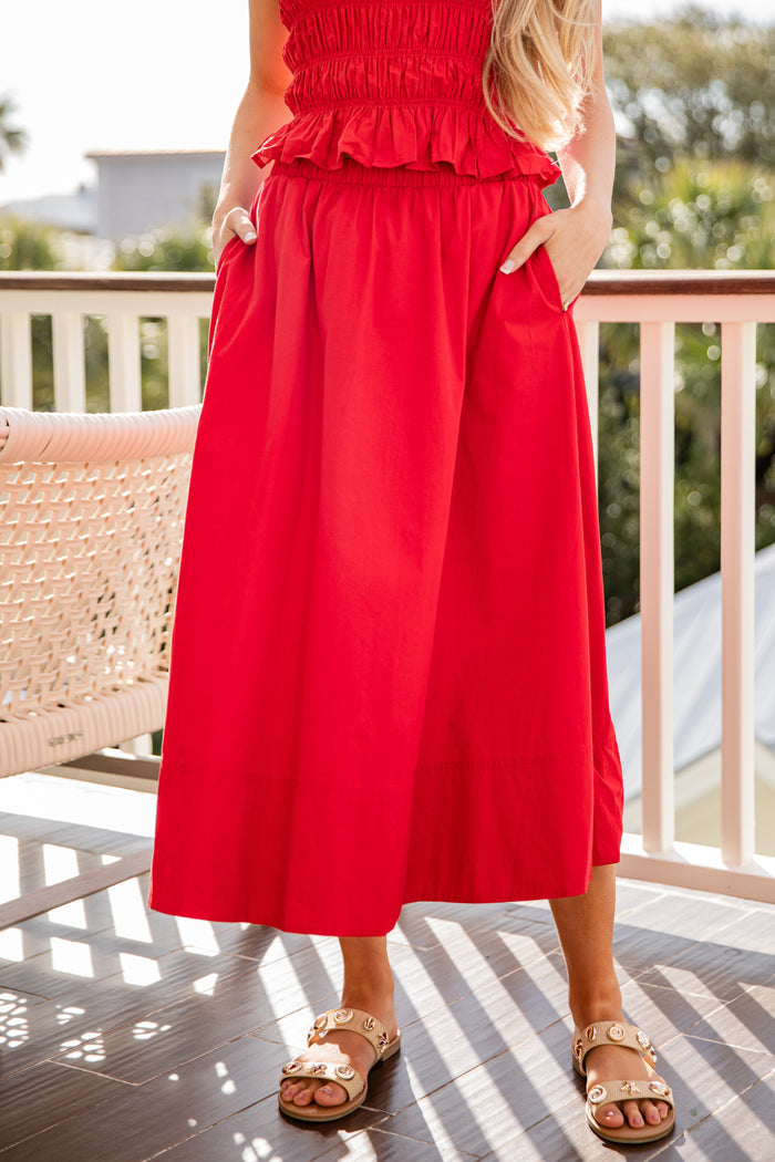 Person wearing a red dress on a balcony