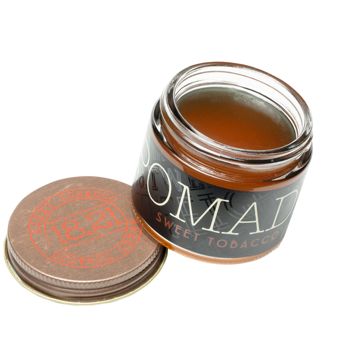 Jar of sweet toffee with a lid on a white background