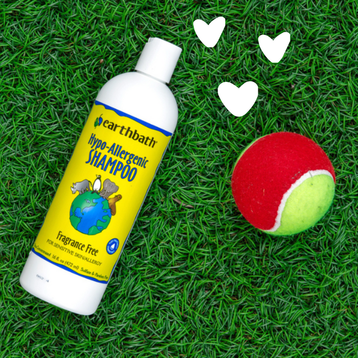 Earthbath hypo-allergenic shampoo bottle on grass with a tennis ball
