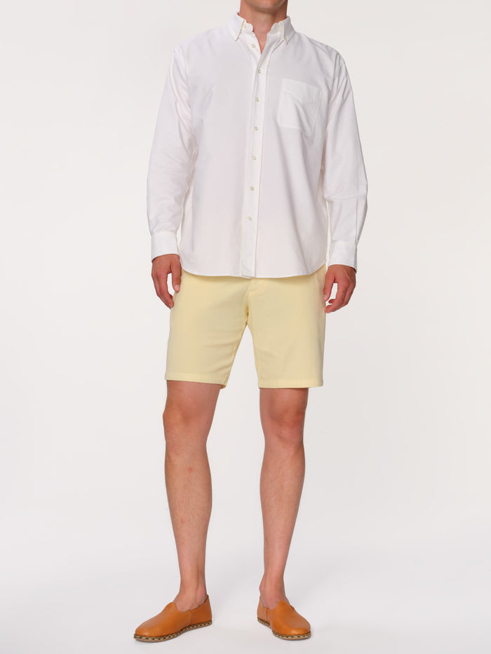 DL1961 men's Jake chino short in pale yellow 'Citron', front view on model in white shirt.