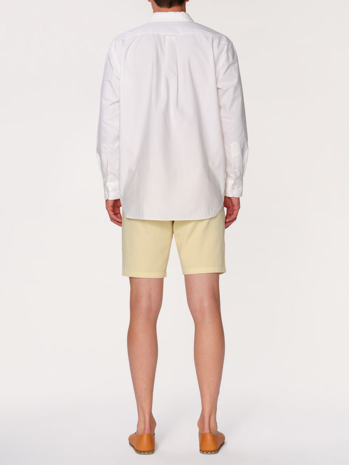 DL1961 men's Jake chino short in pale yellow 'Citron', back view on model in white shirt.