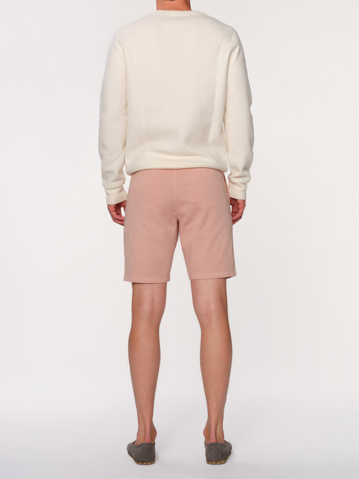 DL1961 men's Jake chino short in dusty pink 'Rose Smoke', back view on model in cream sweater.