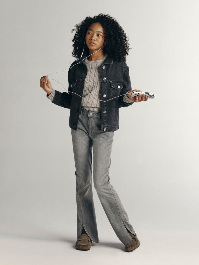 DL1961 girls' Jordyn trucker jacket in washed charcoal 'Nightspell' over a cable sweater, front view on model.