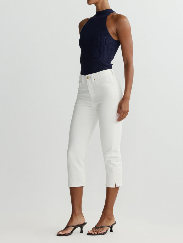 DL1961 women's Mock Neck Top in navy 'Bright Navy', ribbed knit, side view on model with white jeans.