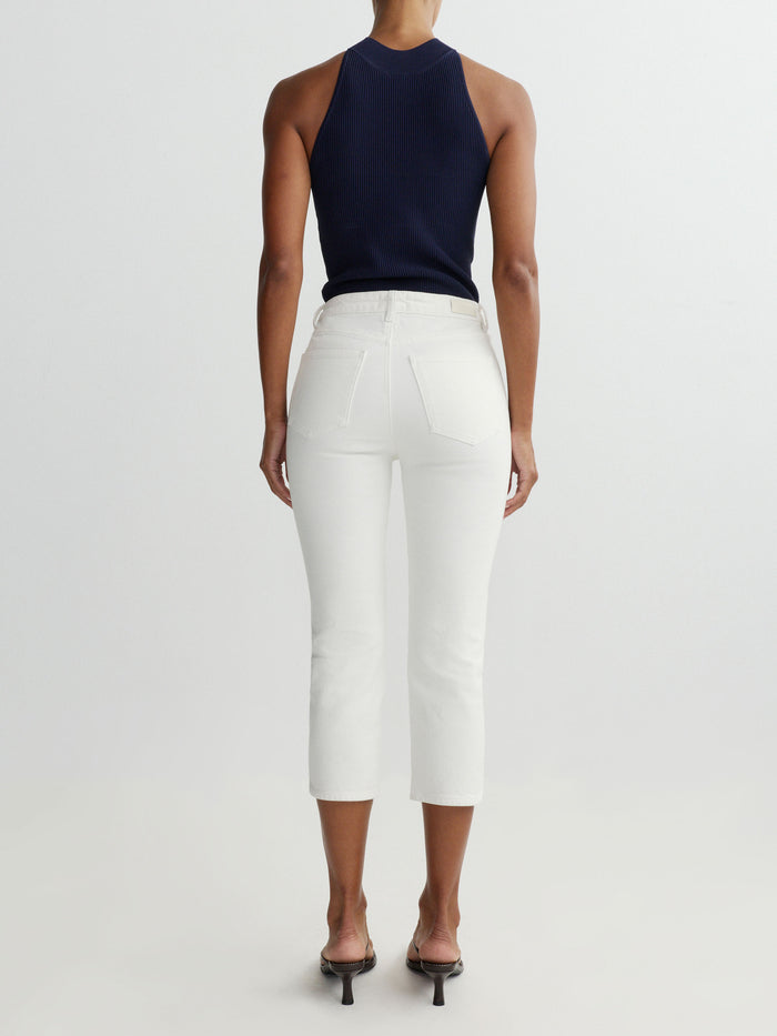DL1961 women's Mock Neck Top in navy 'Bright Navy', ribbed knit, back view on model with white jeans.