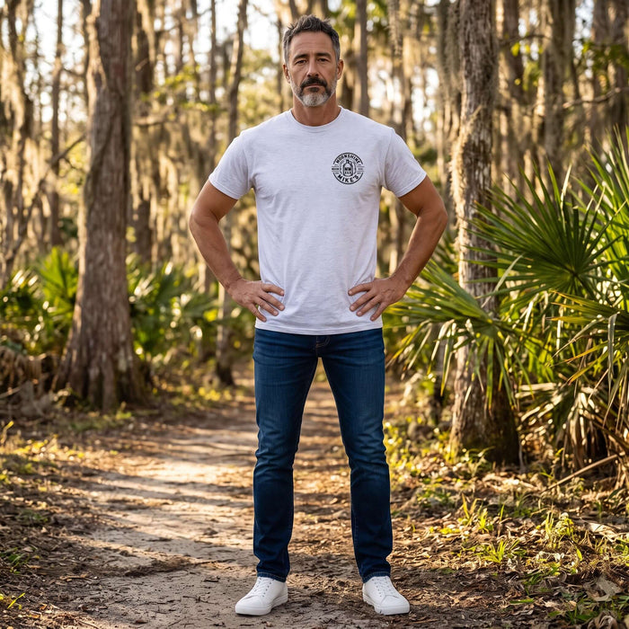 Fort Denaud Beard and Skin grey cotton t-shirt with Moonshine Mike's logo worn by a man on a forest trail