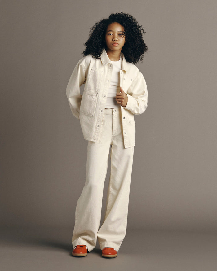 DL1961 girls' Olivia shirt in cream 'Sugar Cookie' worn open over a white tee with wide-leg jeans, front view.