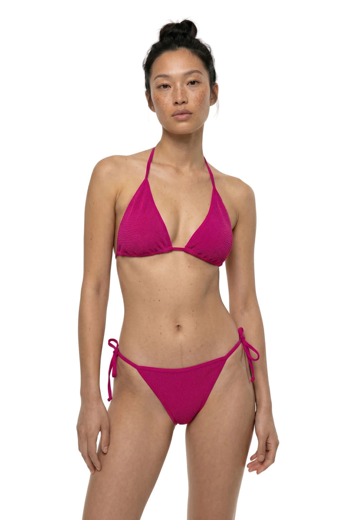 Woman wearing a pink bikini on a white background