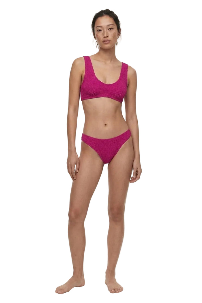 Woman wearing a pink bikini on a white background