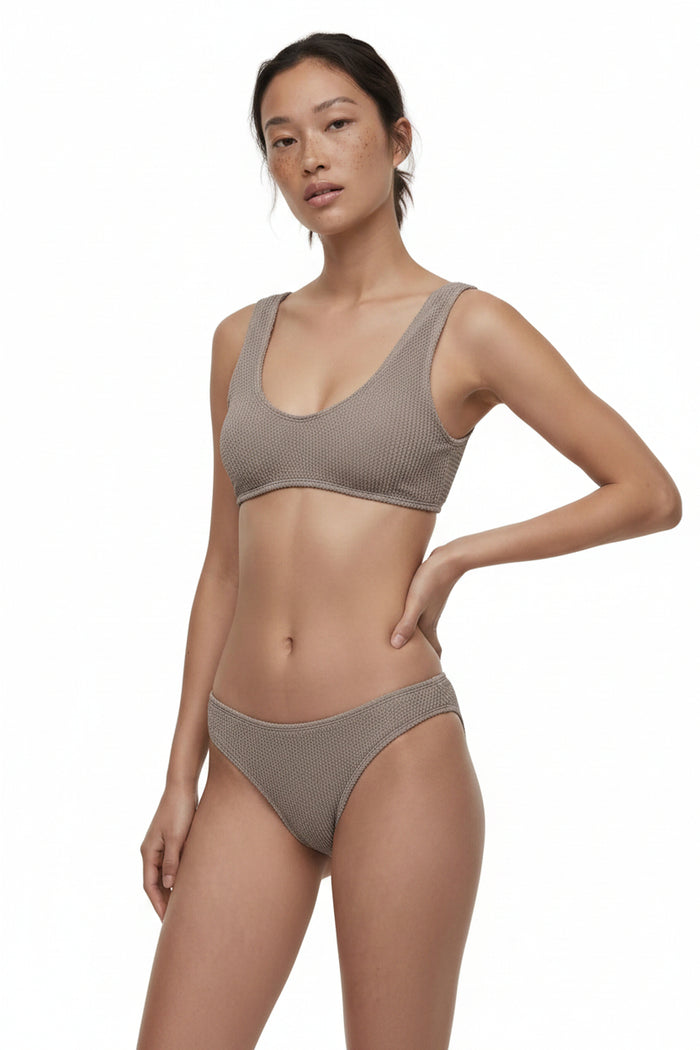Woman wearing a brown bikini set on a white background