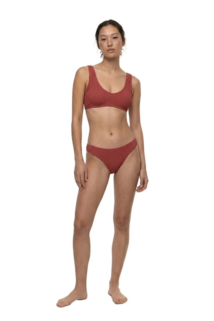 Woman wearing a red bikini set on a white background