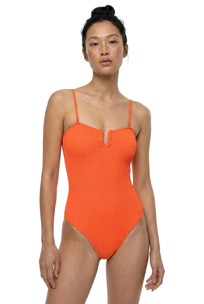 Woman wearing an orange swimsuit on a white background