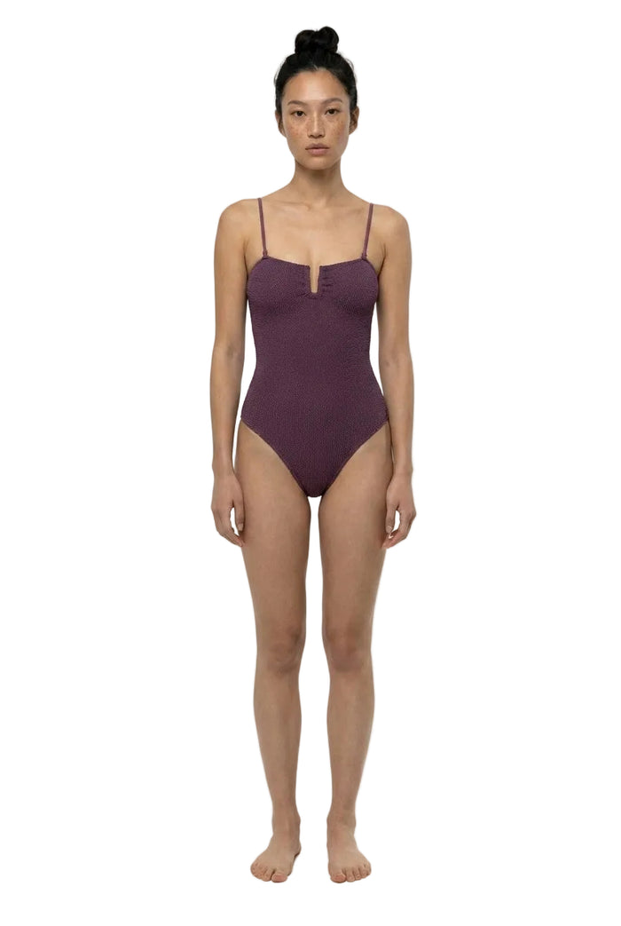 Woman wearing a purple swimsuit on a white background