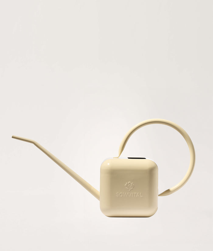Beige watering can on a light gray background.