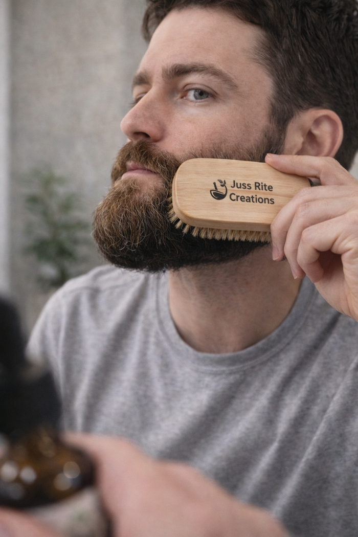 Man grooming his beard with a wooden brush labeled 'Juss Rite Creations'.