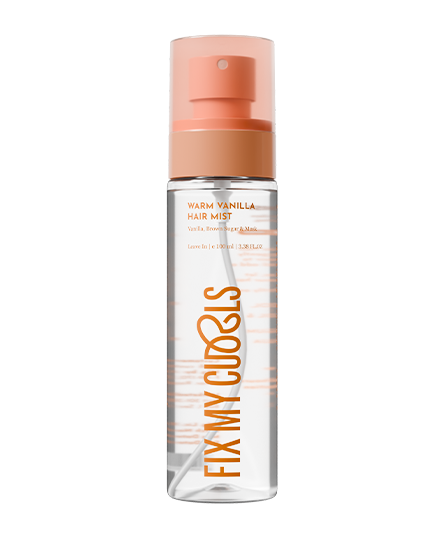 The bottle of Fix My Curls' Warm Vanilla Hair Mist with peach-colored cap on a white background